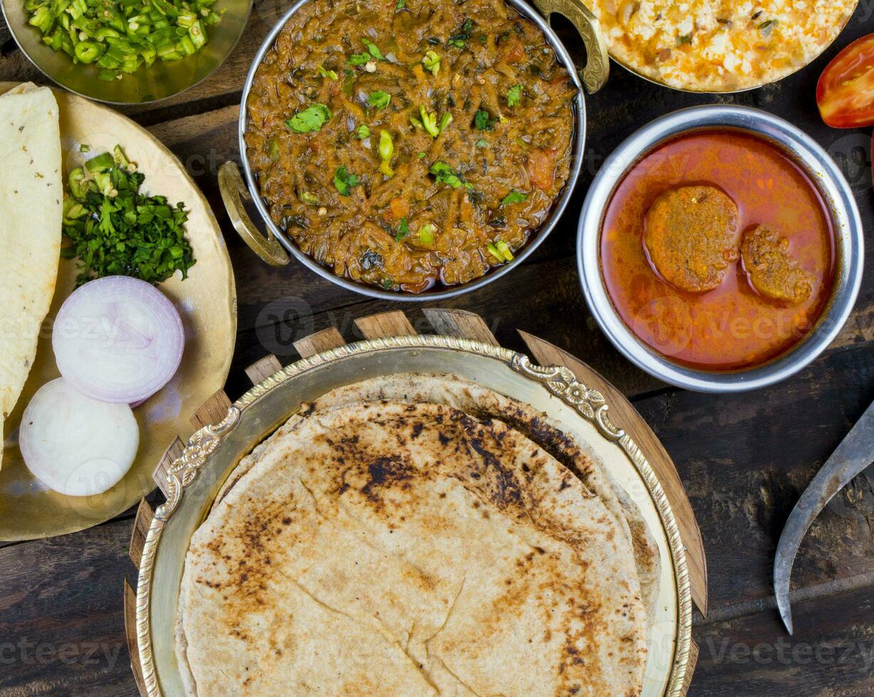 indiano cozinha chapati com set tatar, gatta Curry, raita, papad ou cebola em de madeira fundo foto