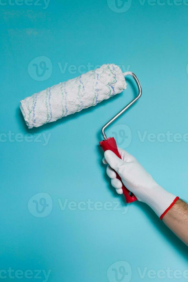 imagem do homem segurando pintura rolo dentro frente do azul muro. foto