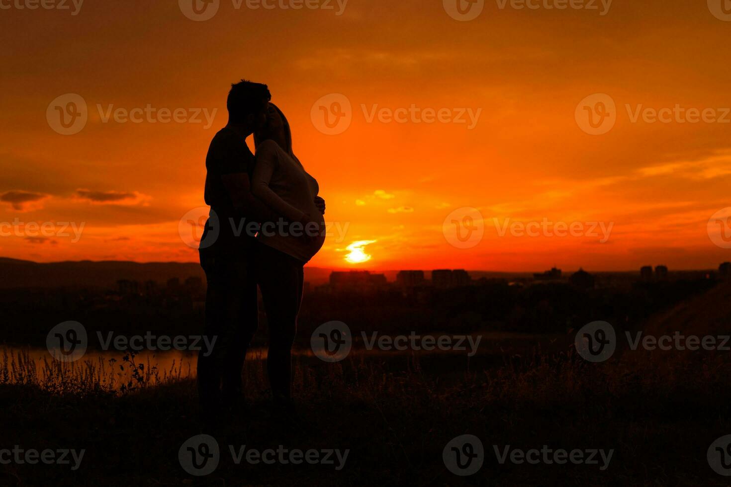 silhuetas do marido e grávida esposa apreciar gastos Tempo juntos ao ar livre.toned imagem. foto