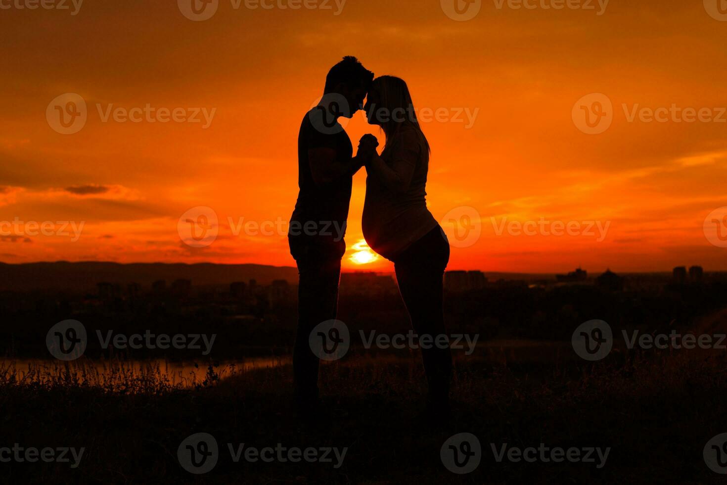 silhuetas do marido e grávida esposa apreciar gastos Tempo juntos ao ar livre.toned imagem. foto