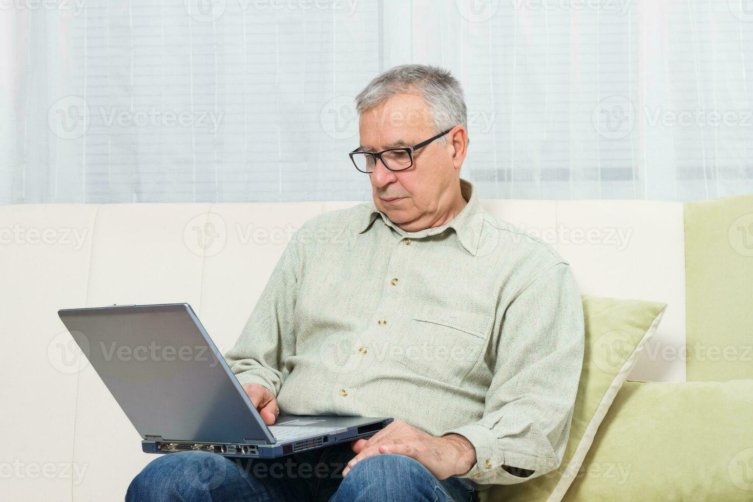 Senior homem usando computador portátil. foto