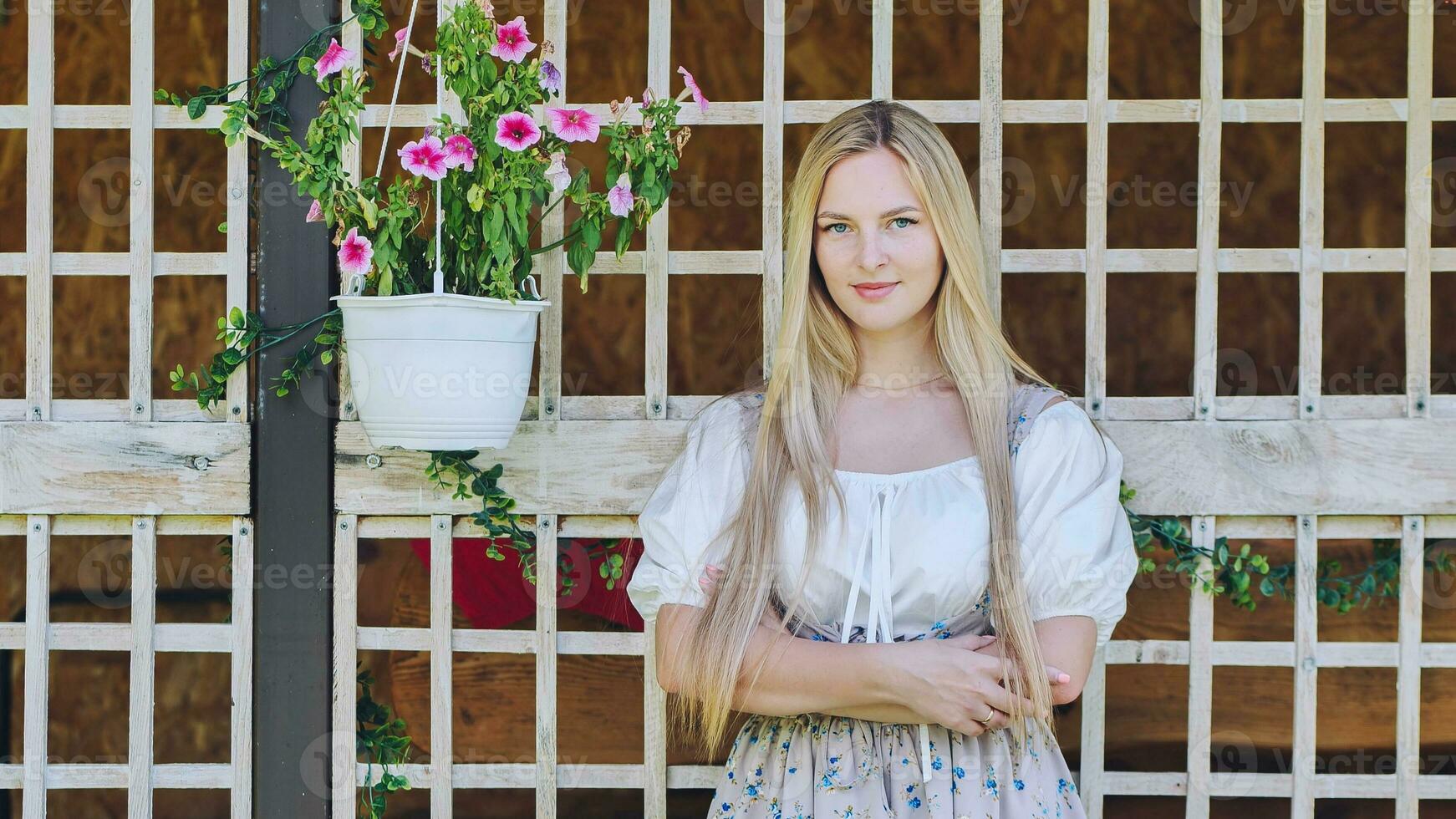 uma menina do eslavo aparência poses às casa com flores foto