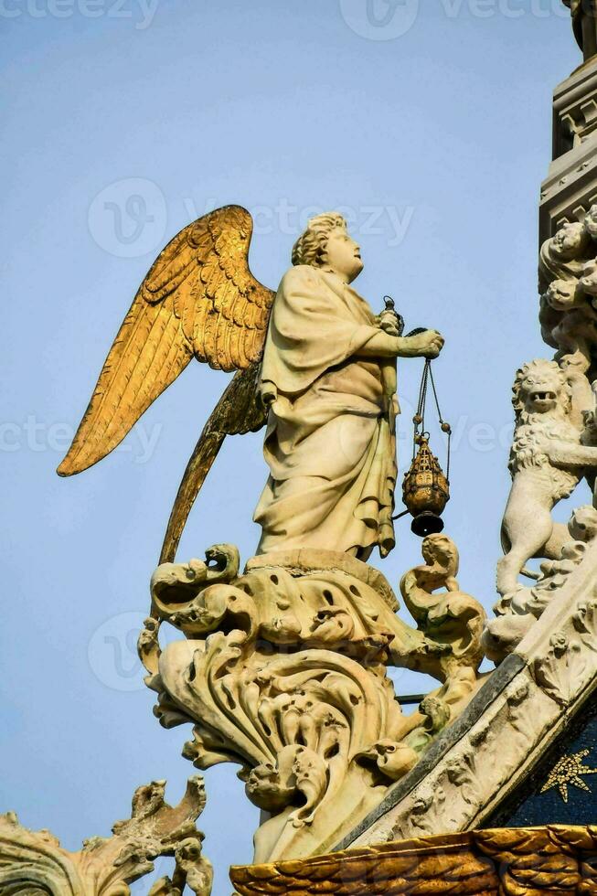 uma estátua do a anjo em topo do uma construção foto