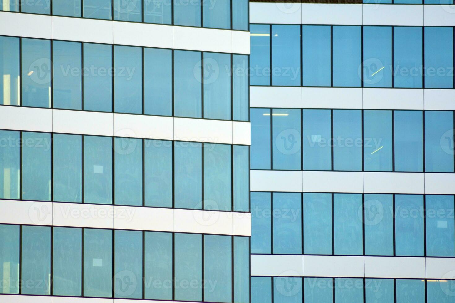 vidro construção com transparente fachada do a construção e azul céu. estrutural vidro parede refletindo azul céu. abstrato moderno arquitetura fragmento. contemporâneo arquitetônico fundo. foto