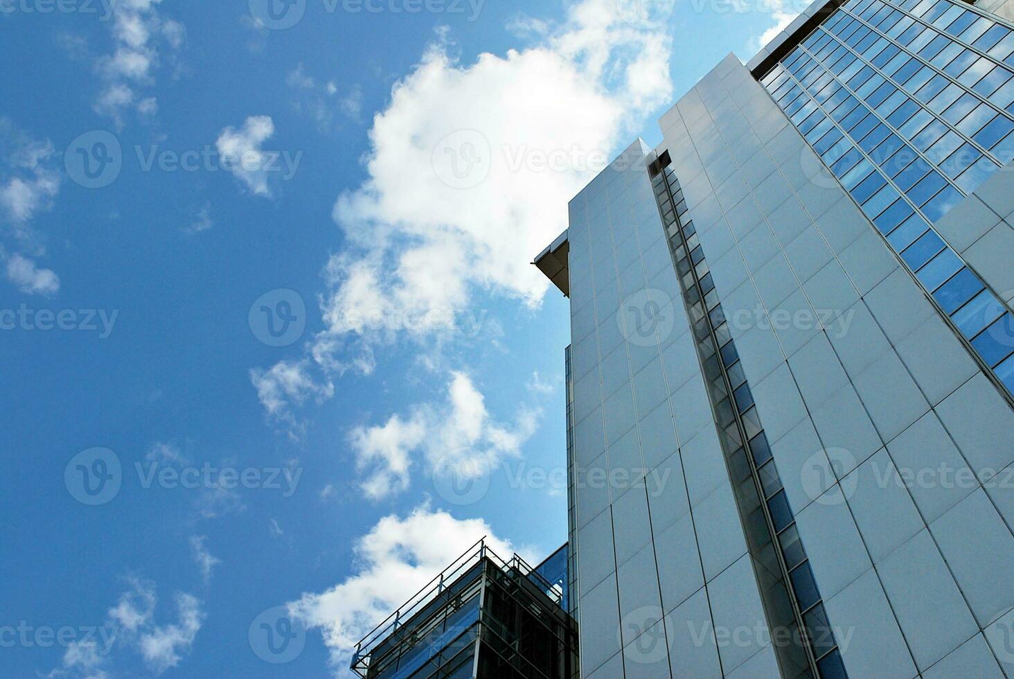 vidro construção com transparente fachada do a construção e azul céu. estrutural vidro parede refletindo azul céu. abstrato moderno arquitetura fragmento. contemporâneo arquitetônico fundo. foto