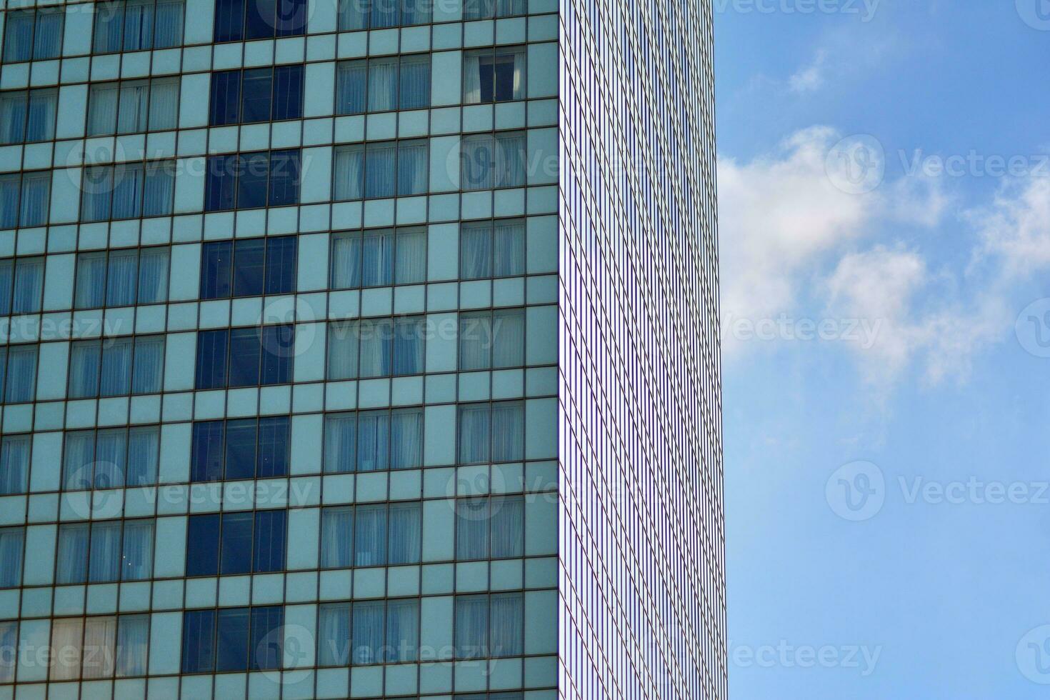 vidro construção com transparente fachada do a construção e azul céu. estrutural vidro parede refletindo azul céu. abstrato moderno arquitetura fragmento. contemporâneo arquitetônico fundo. foto