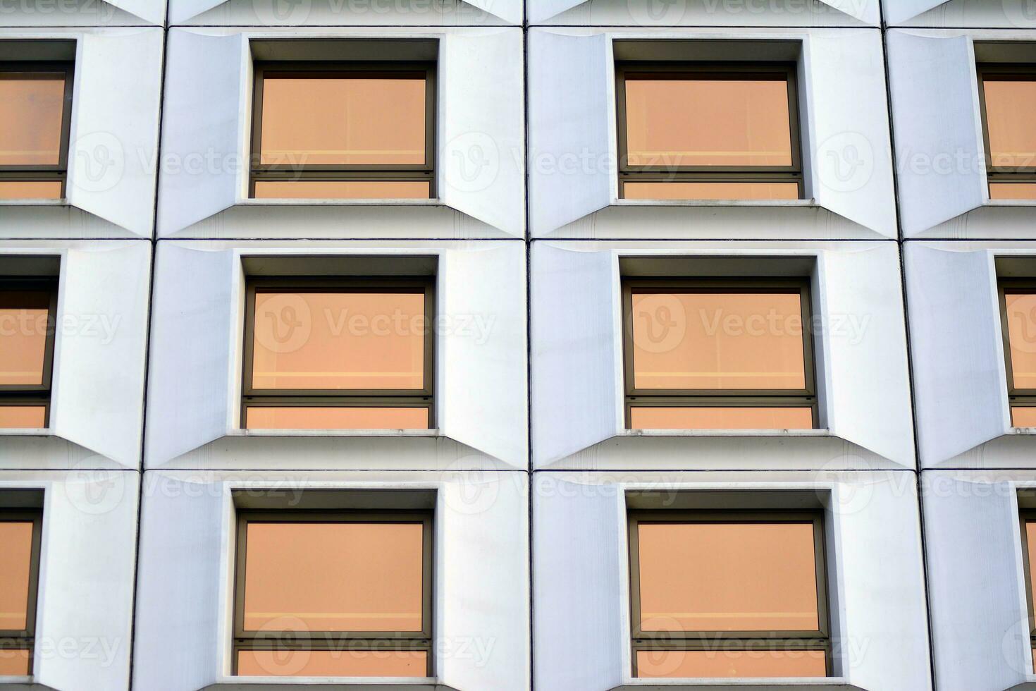 moderno escritório construção dentro a cidade com janelas e aço e alumínio painéis muro. contemporâneo comercial arquitetura, vertical convergindo geométrico linhas. foto