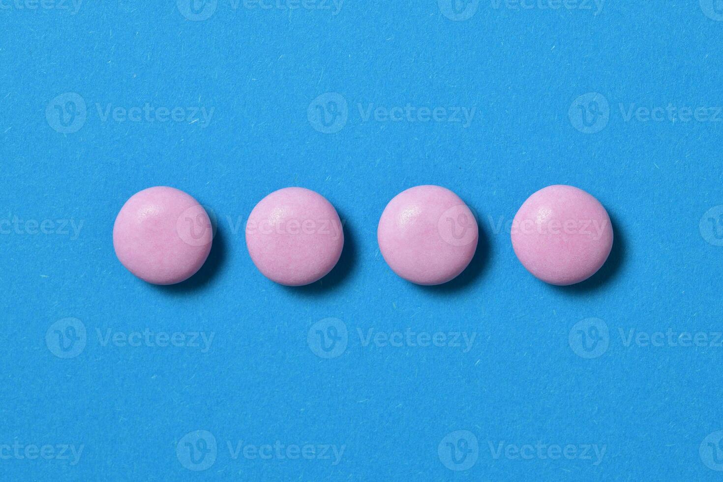 topo Visão do quatro Rosa bombons isolado em azul fundo foto