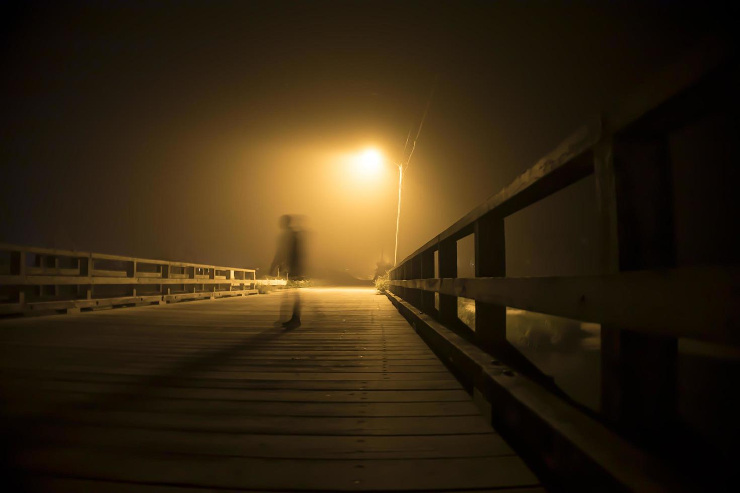 silhueta de um homem sob um poste de luz foto