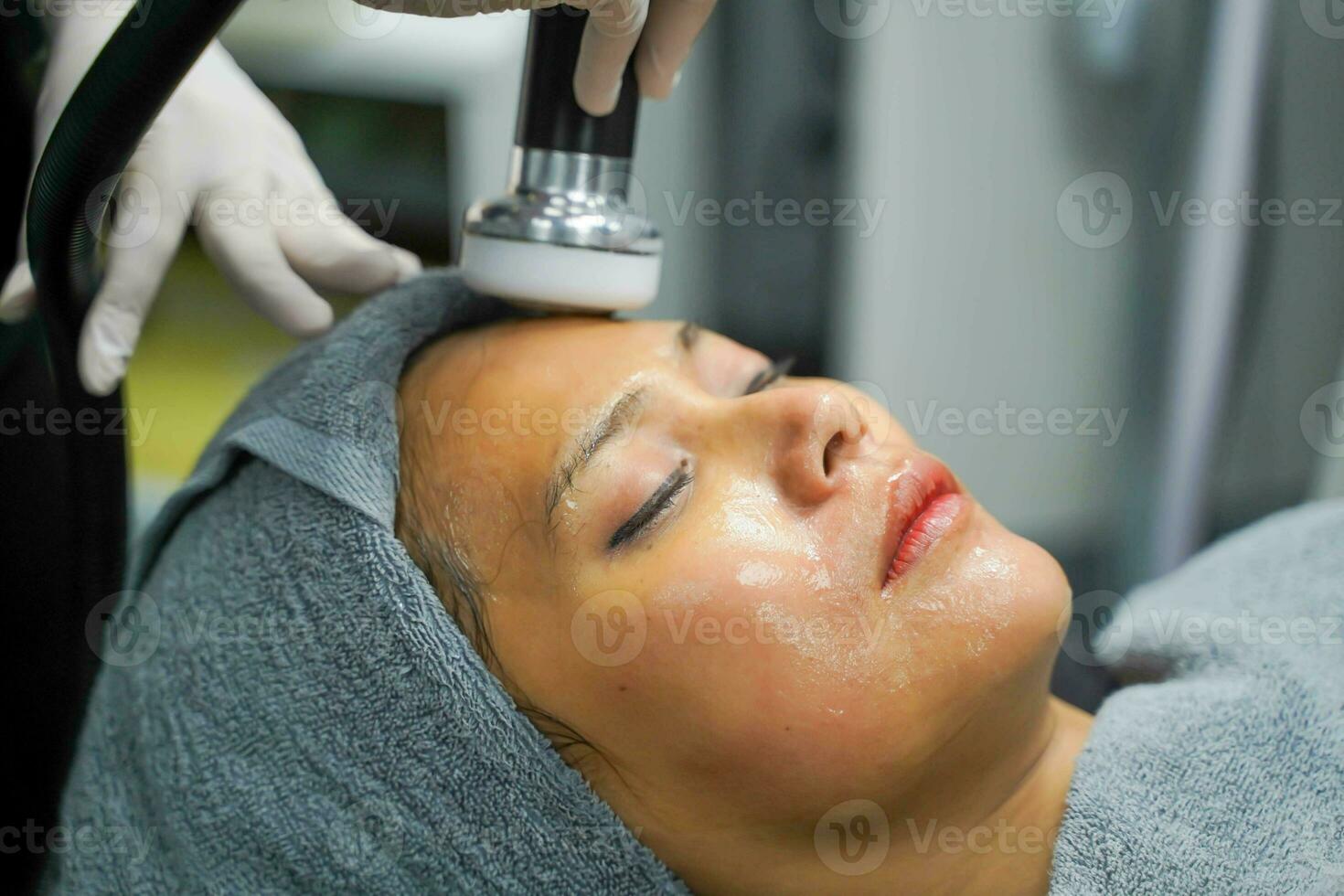 fechar-se ásia beleza mulher tendo terapia para estimular facial pele e facial ultrassônico cuidados com a pele tratamento de profissional cosmetologista bem-estar. foto