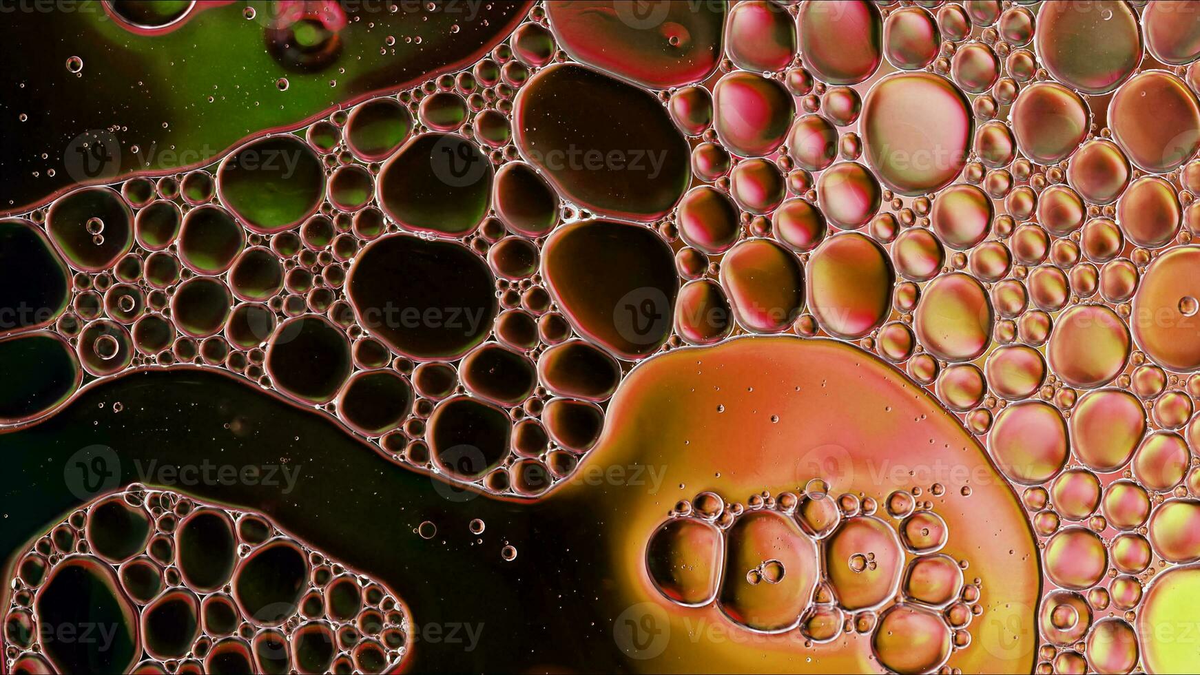óleo de comida colorida abstrata gotas de bolhas e esferas fluindo na superfície da água foto