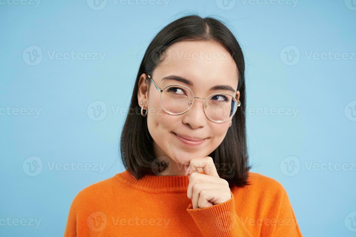 retrato do pensativo coreano mulher dentro copos, pensando e olhando aparte, tem a ideia, planos smth, carrinhos sobre azul fundo foto