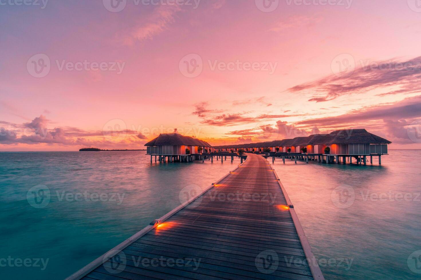 panorama incrível do pôr do sol nas maldivas. luxo resort vilas vista do mar com luzes LED suaves sob o céu colorido. lindo céu crepuscular e nuvens coloridas. fundo de praia lindo para férias de férias foto