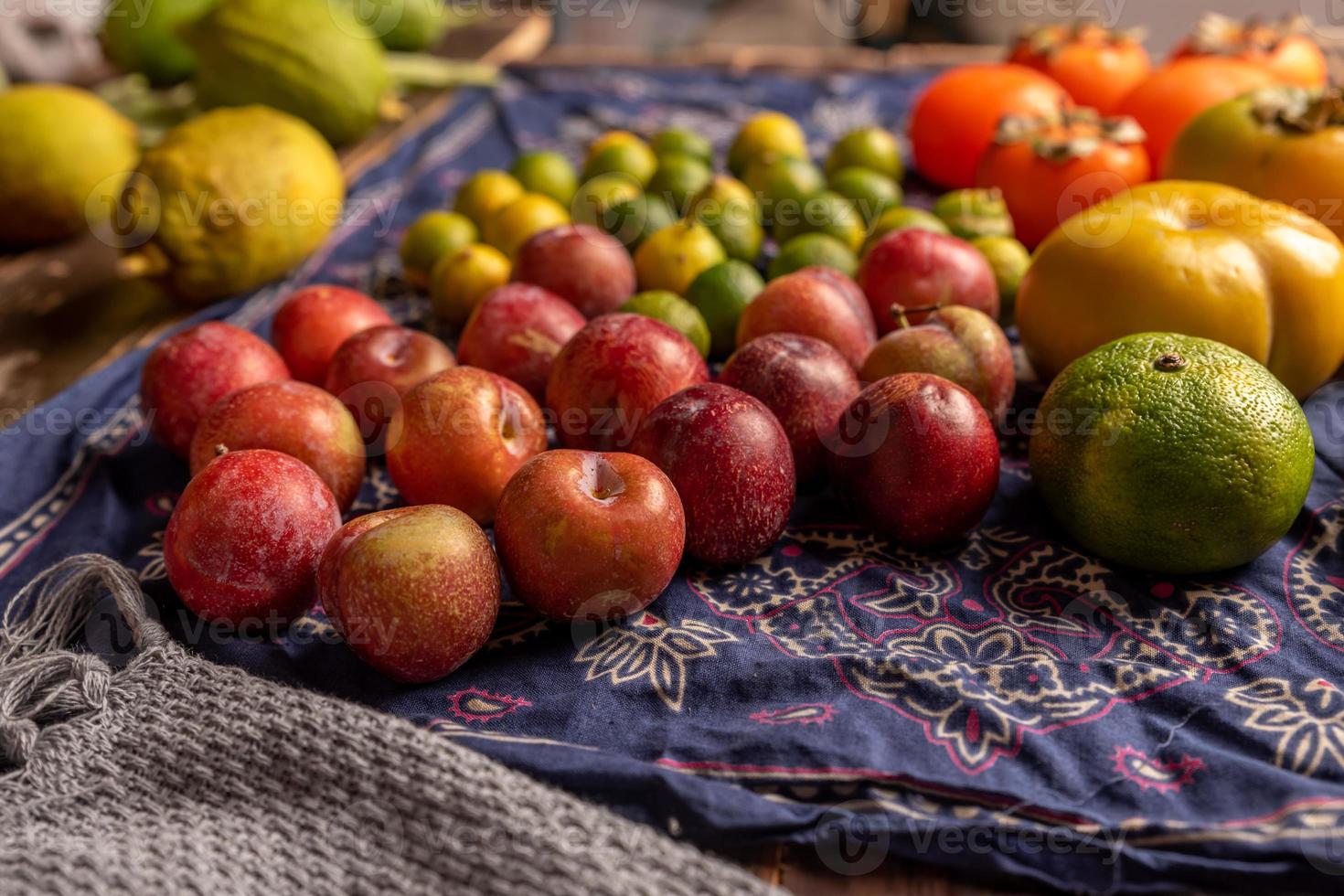 muitas cores e variedades de frutas estão na mesa de grãos de madeira foto