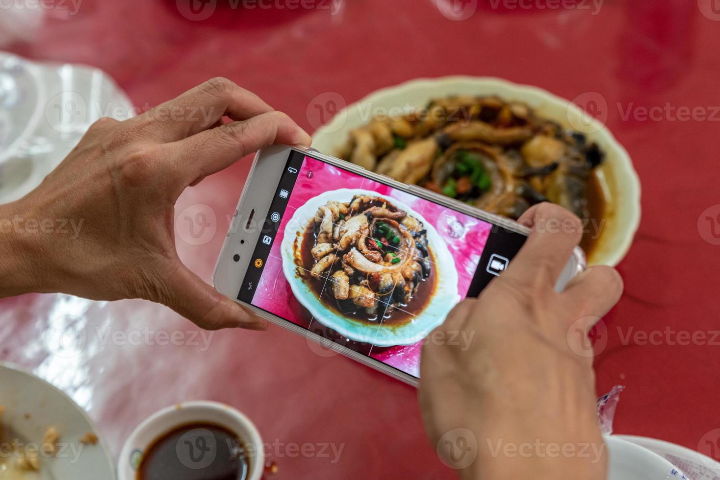 um homem está tirando fotos com um celular na mão