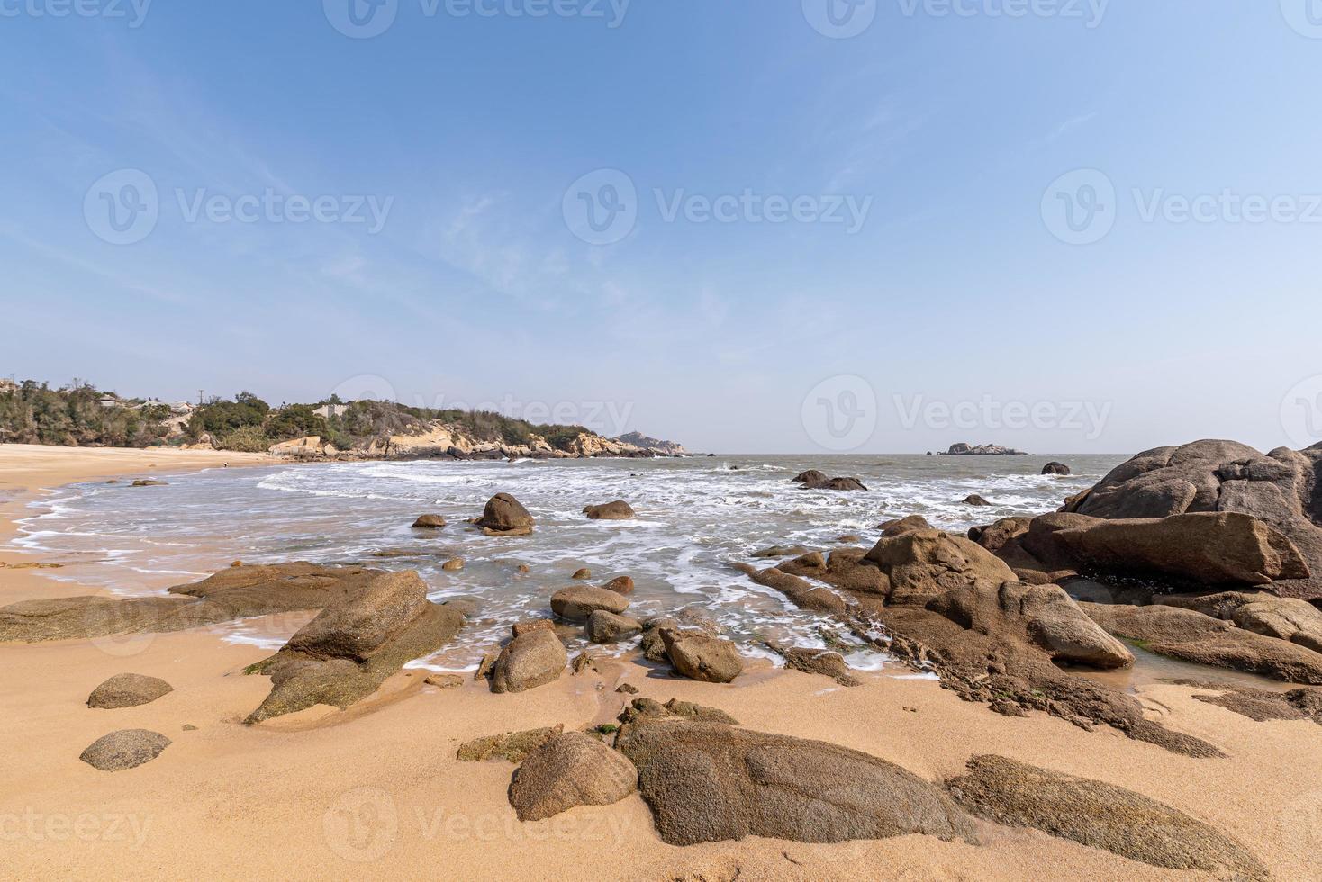 o céu é azul no verão. o mar tem praias douradas, ondas e recifes foto