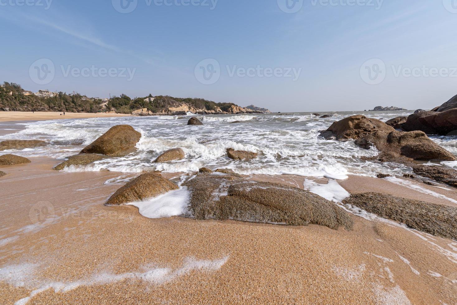 o céu é azul no verão. o mar tem praias douradas, ondas e recifes foto