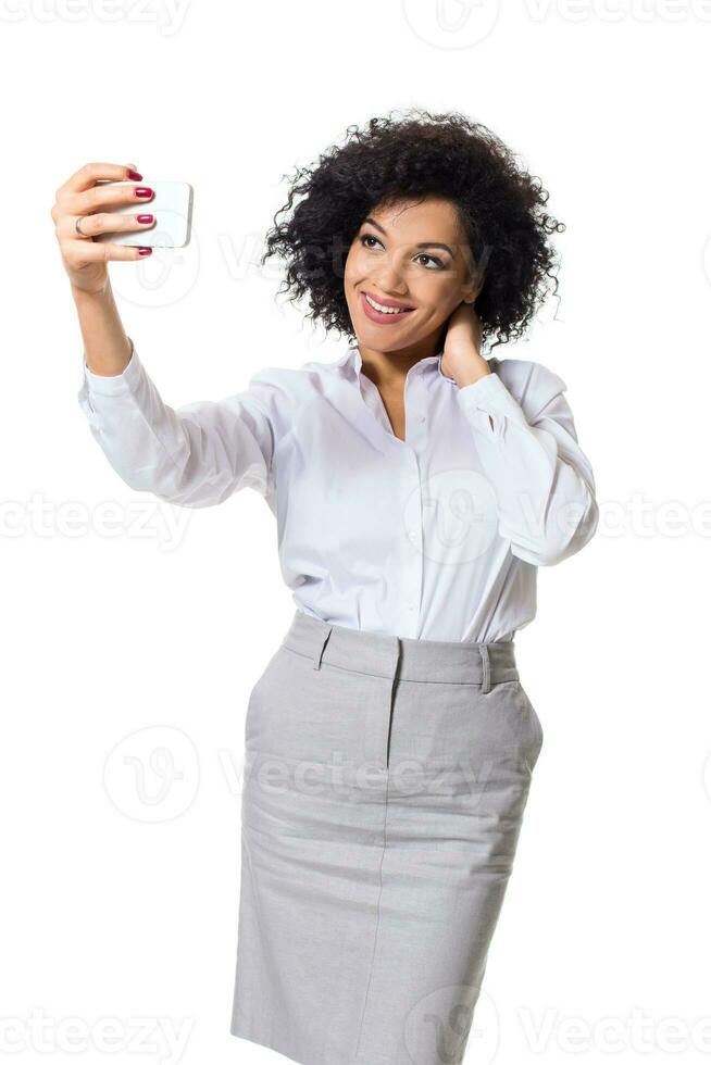 lindo morena mulher dentro clássico branco camisa e saia faço selfie em a telefone. foto