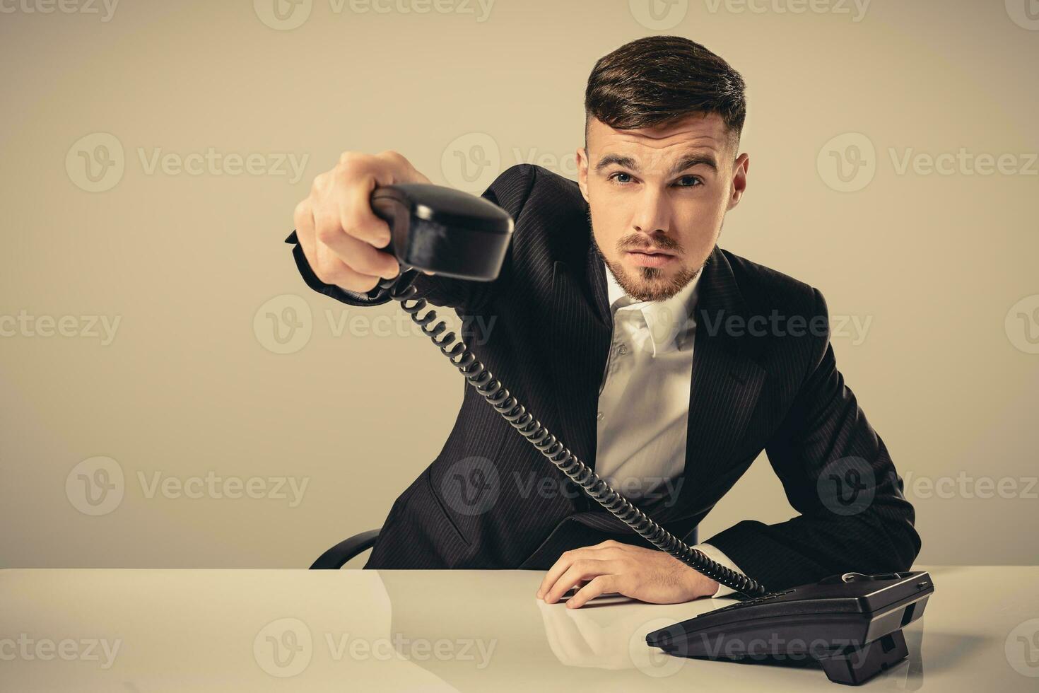 retrato do atraente homem de negocios segurando Telefone dentro dele mão foto