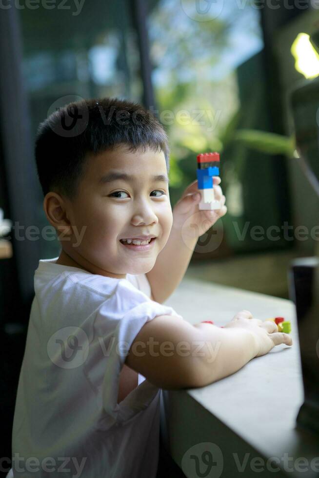 ásia crianças cheio de dentes sorridente face jogando criança brinquedo às casa vivo quarto foto