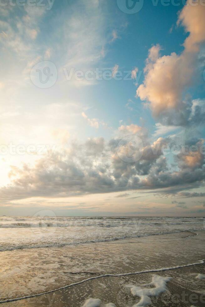 tirar o fôlego pôr do sol em a margens do a norte mar perto Zandvoort, Holanda. abstrato Visão do a mar superfície e a colorida céu foto