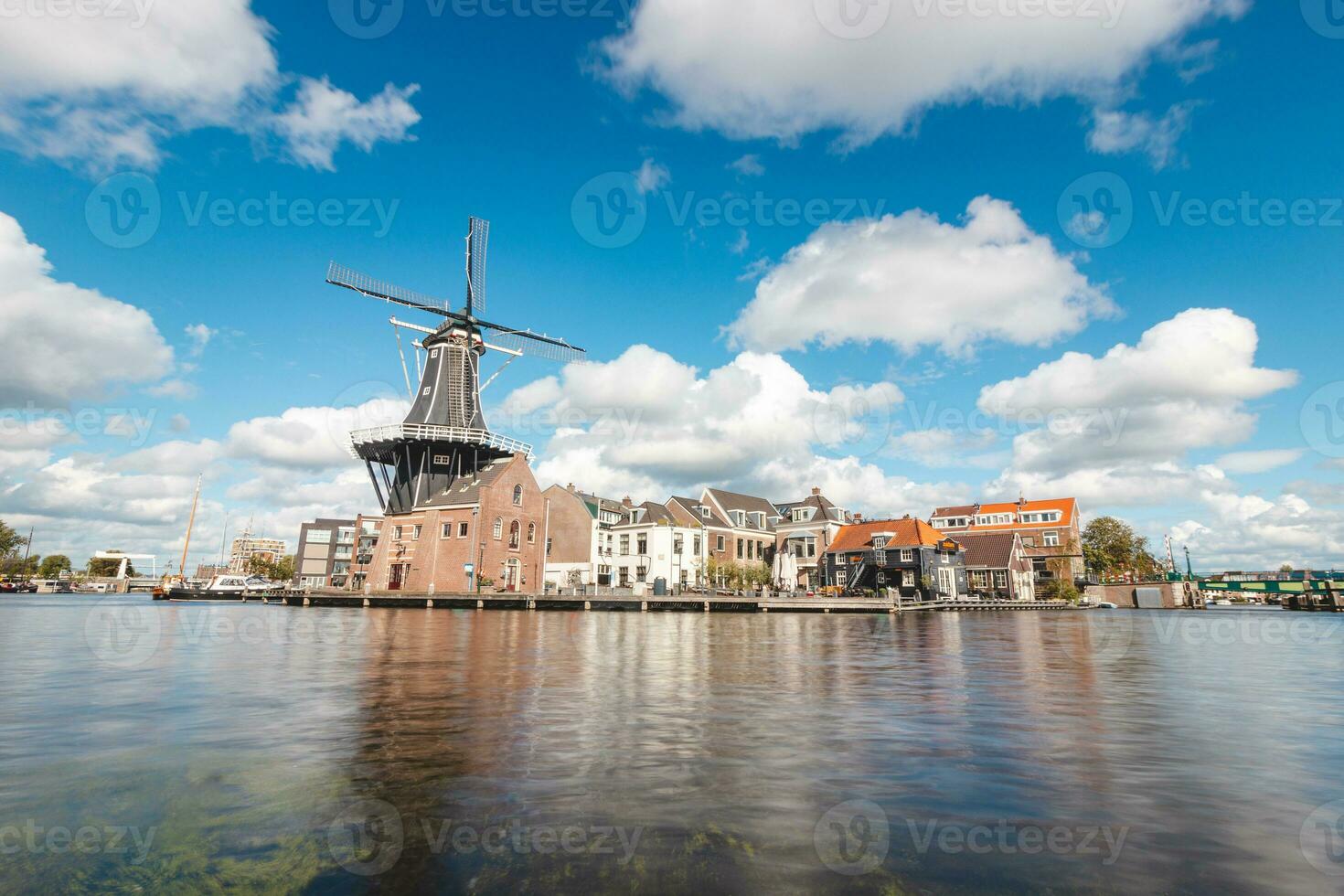 Visão do haarlem cidade Centro com a iluminado histórico moinho e edifícios. típica holandês arquitetura. explorando Holanda foto