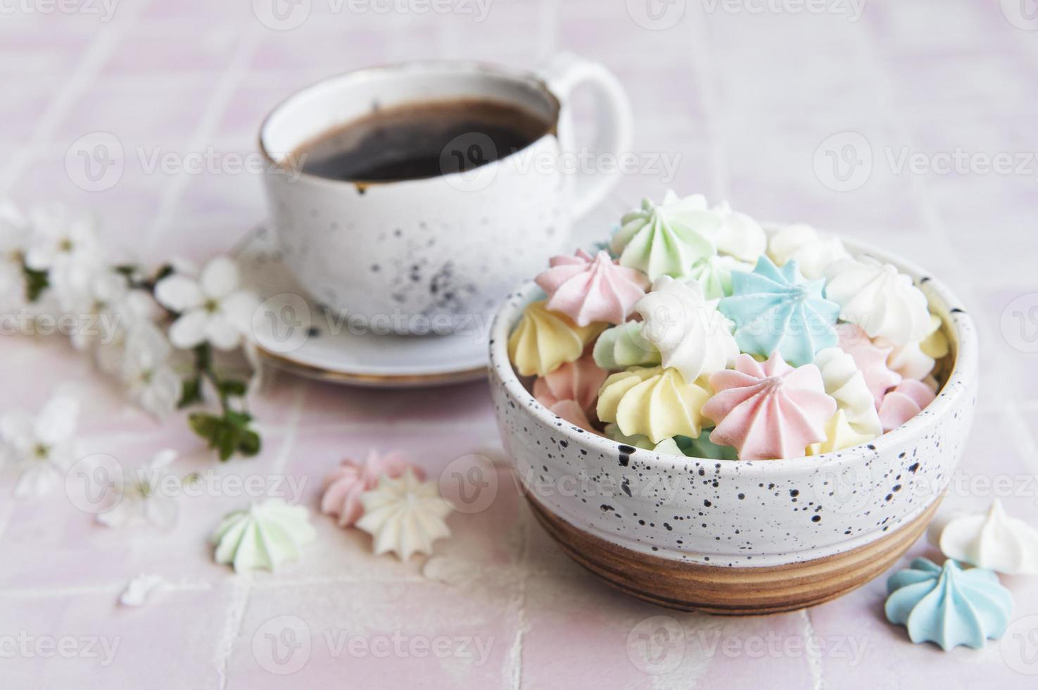 xícara com café e pequenos merengues foto