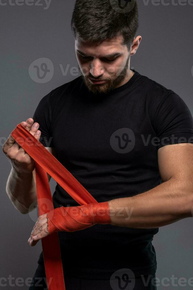 jovem homem invólucro pulsos com vermelho boxe fita foto