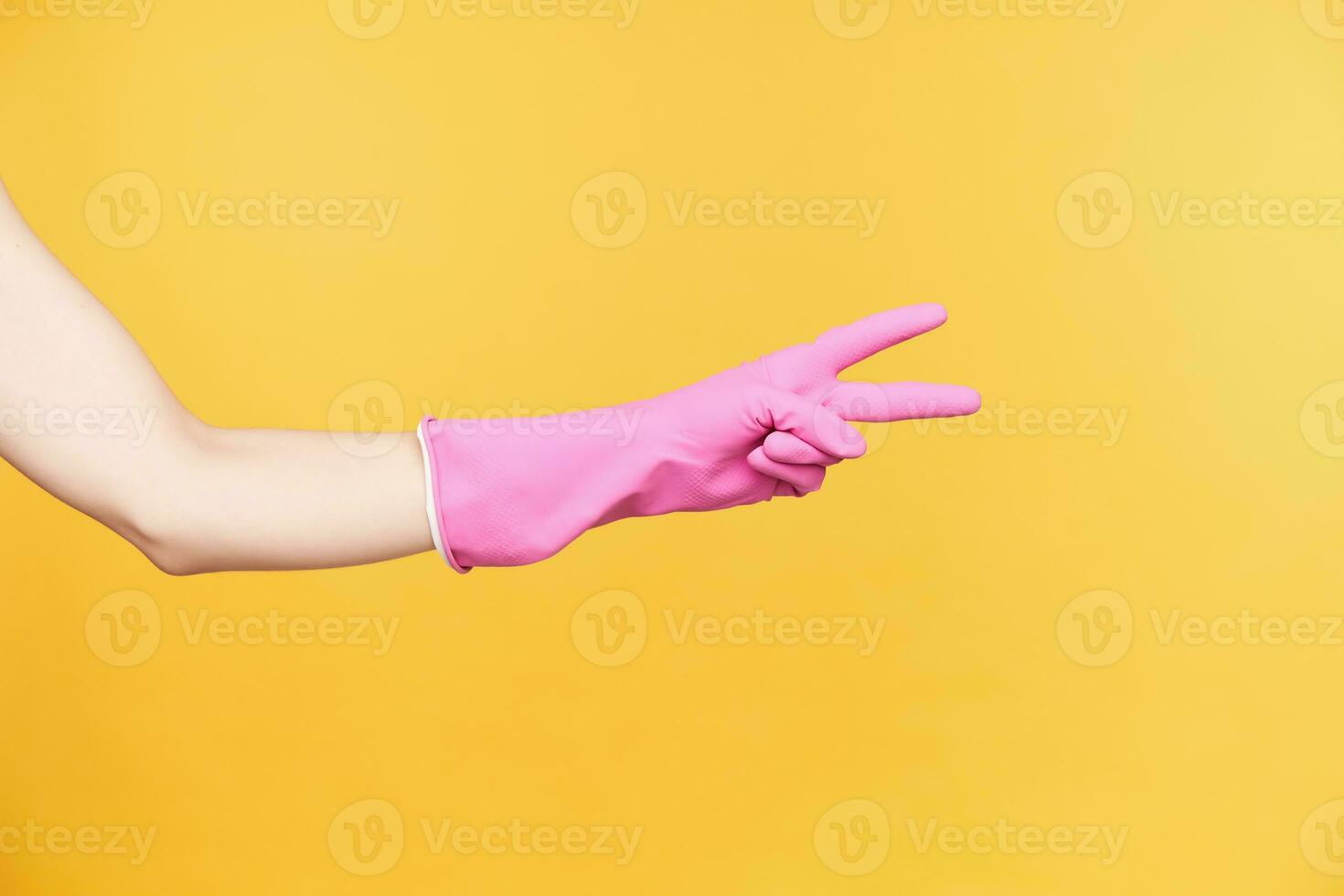 estúdio foto do jovem mulher mão dentro borracha luva formando vitória gesto com dois dedos enquanto ser isolado sobre laranja fundo. sinais e gesticulando conceito