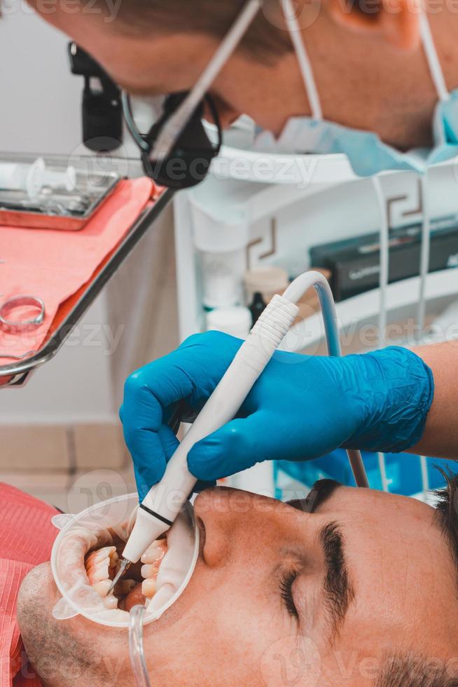 o dentista usa binóculos para o melhor resultado e trabalho foto