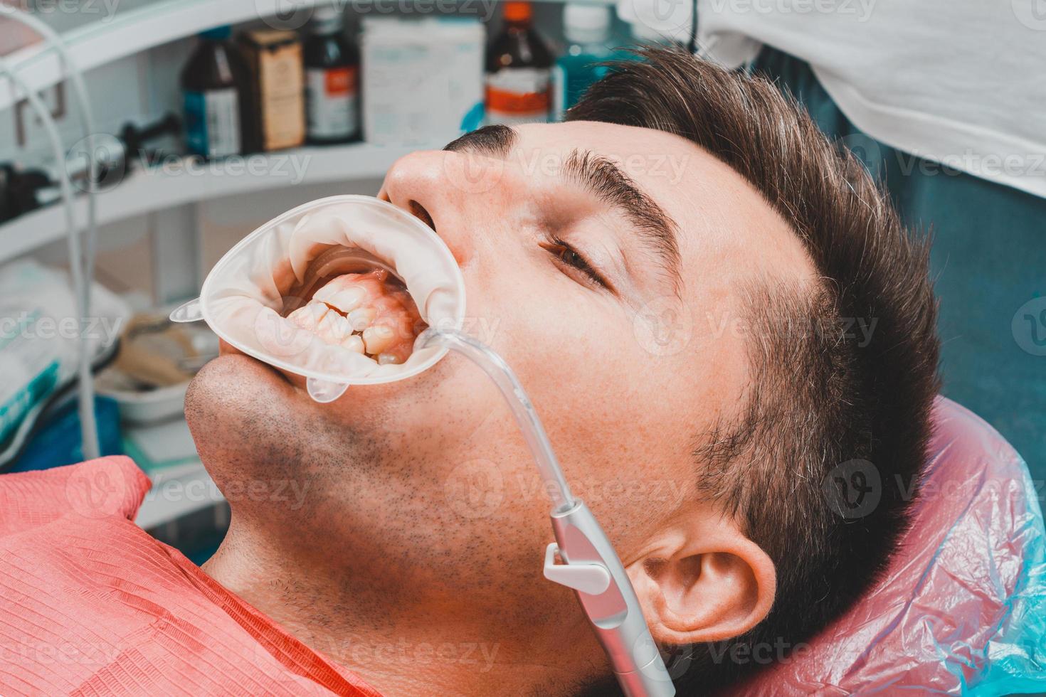 dentista prepara o paciente e ferramentas para remover o tártaro foto