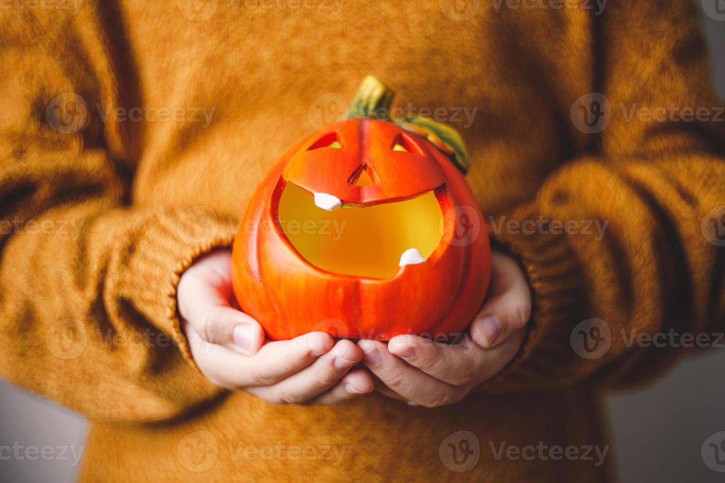 lâmpada de abóbora de halloween nas mãos das crianças. foto