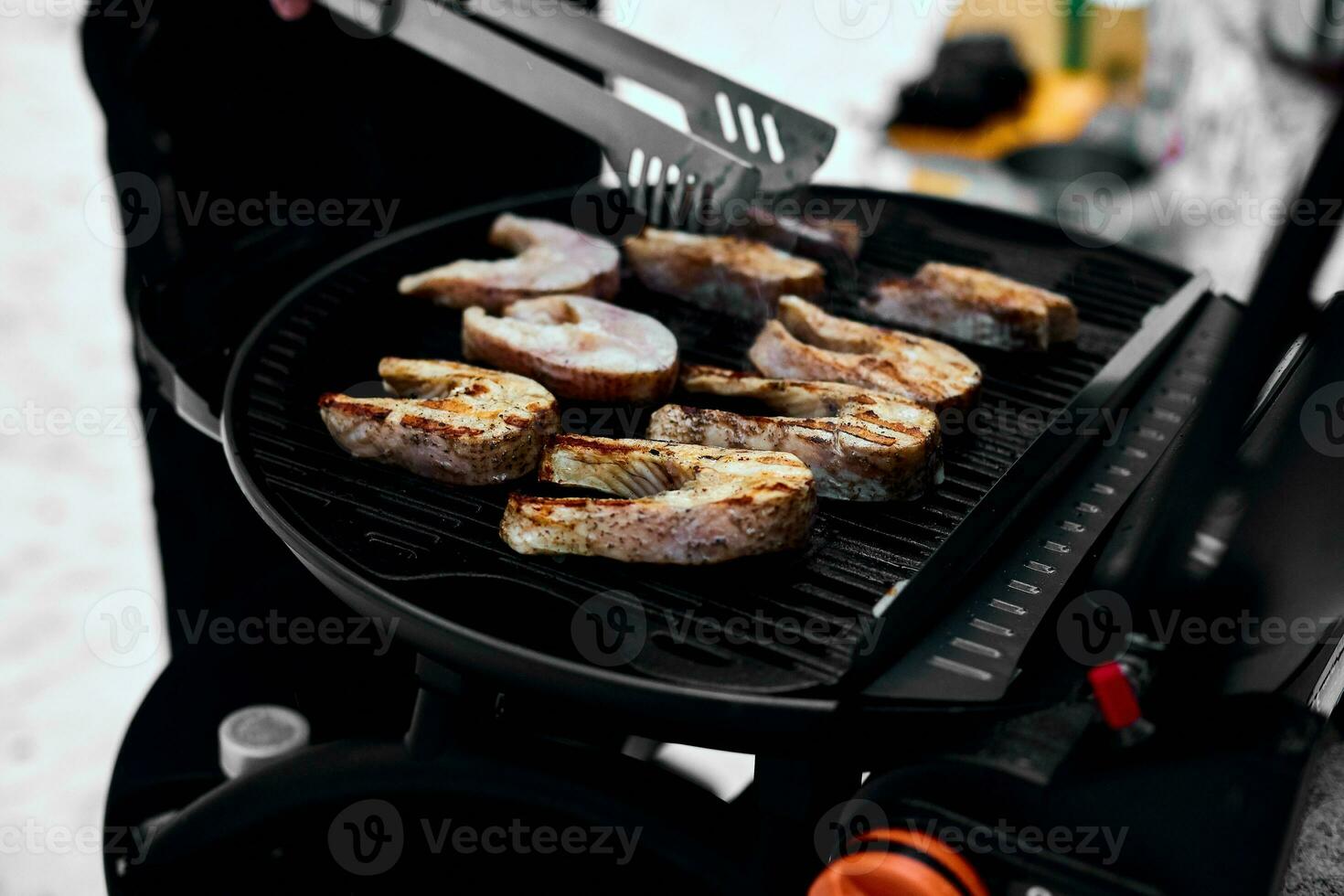 homem grelhar delicioso peixe em uma portátil churrasco, Nevado inverno churrasco foto