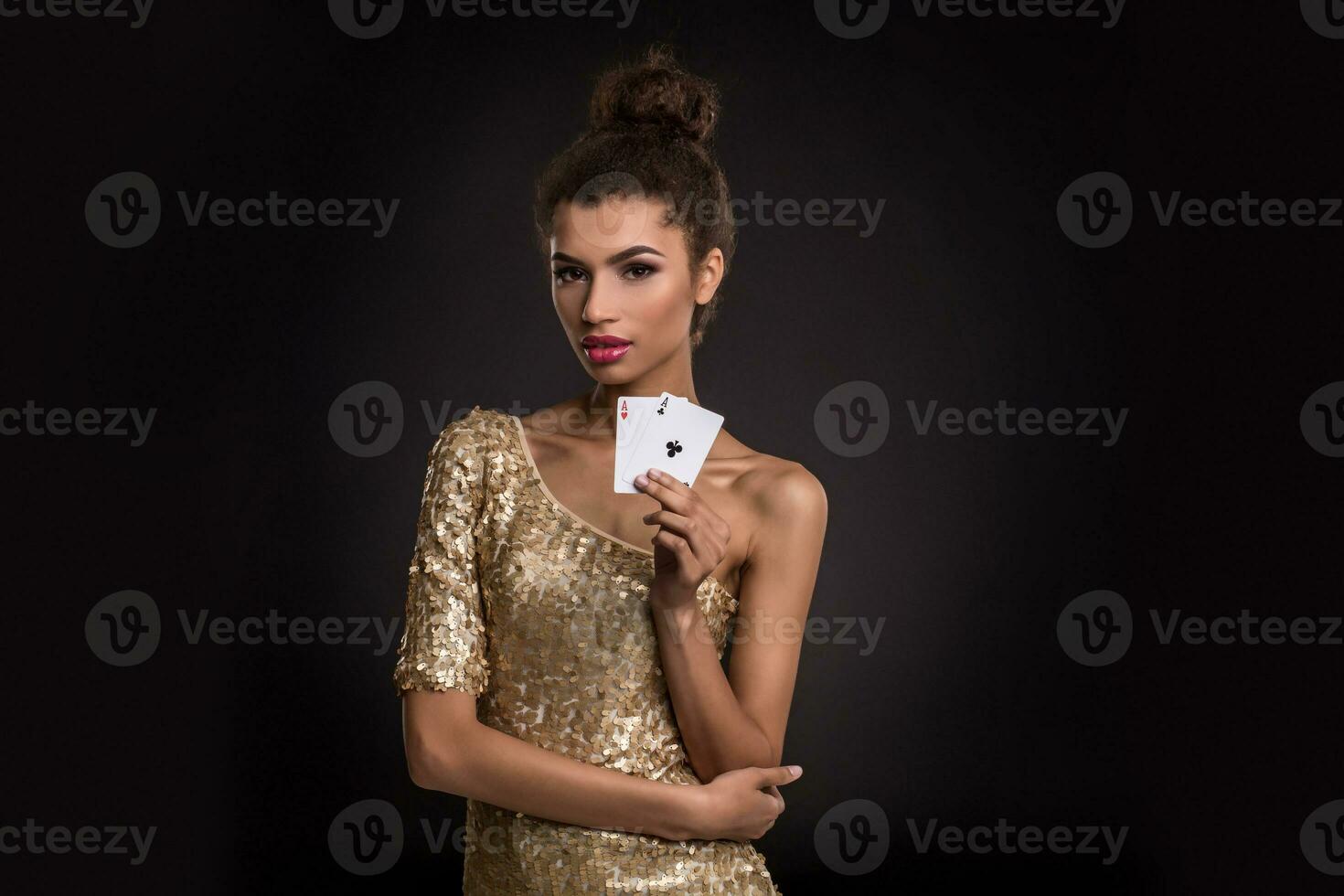 mulher ganhando - jovem mulher dentro uma elegante ouro vestir segurando dois ases, uma pôquer do ases cartão combinação. foto
