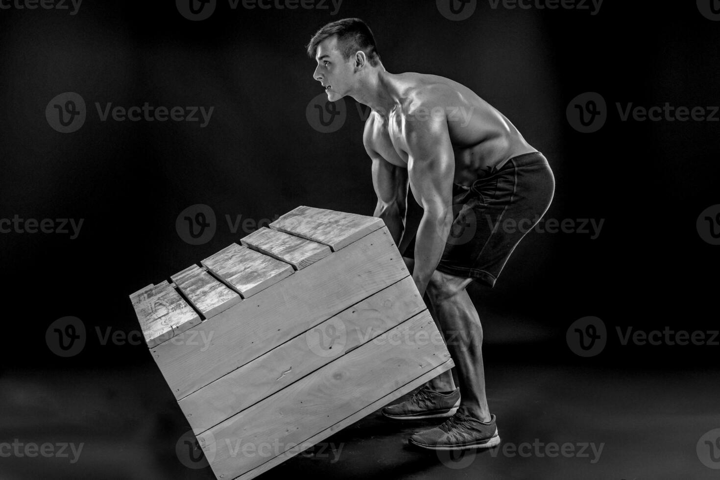 jovem muscular homem lançando caixa foto