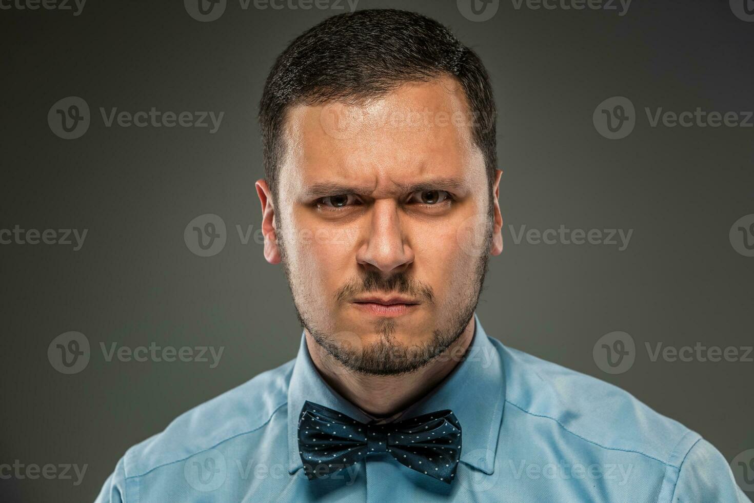 retrato jovem homem dentro azul camisa, olhando com suspeita foto