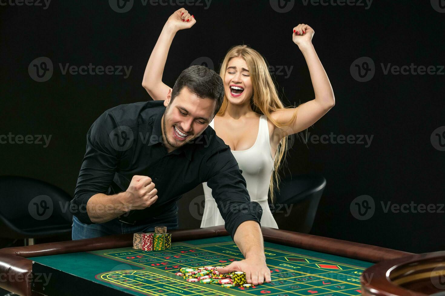 jovem casal a comemorar ganhar às roleta mesa dentro casino. foto
