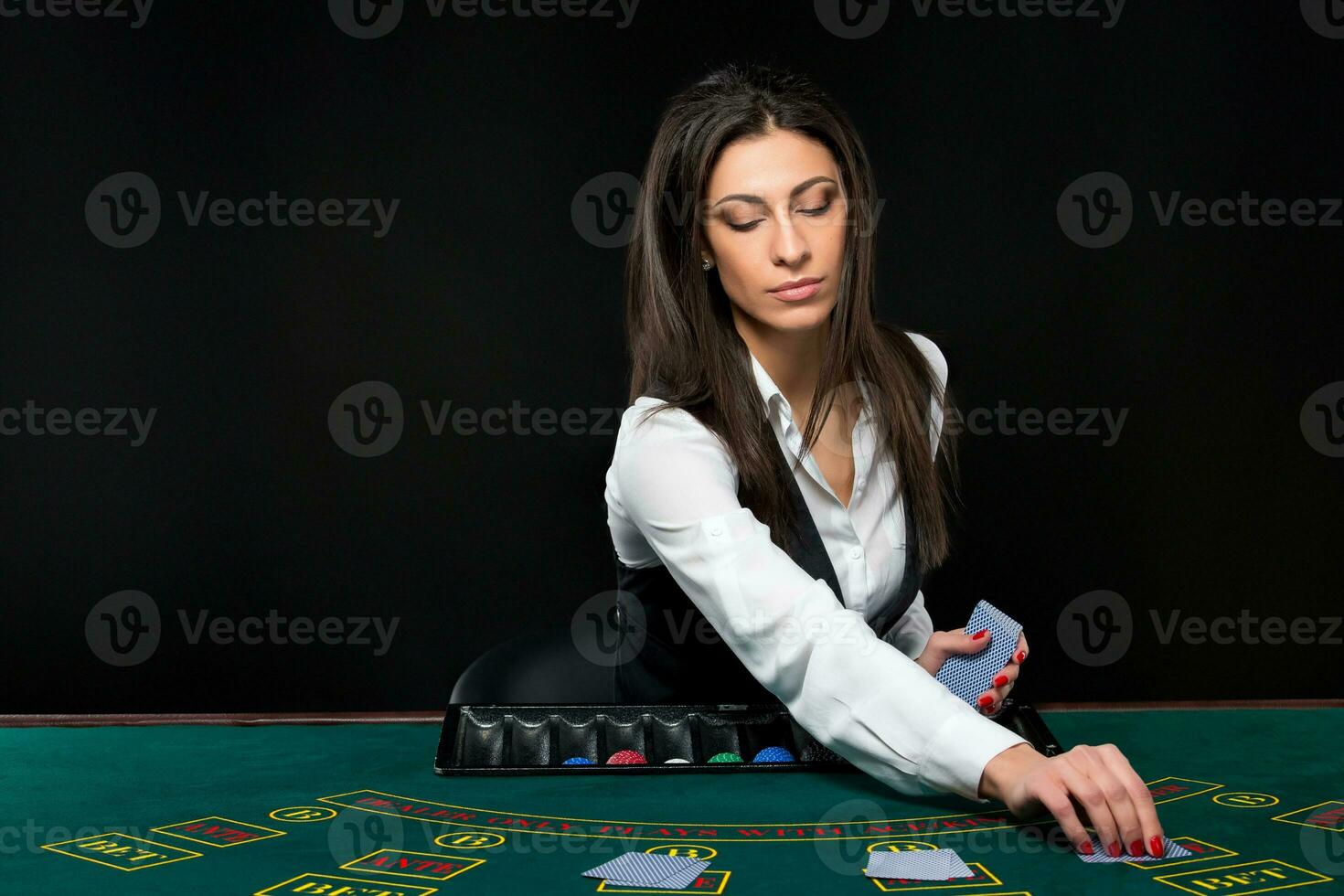 a lindo garota, distribuidor, atrás uma mesa para pôquer foto