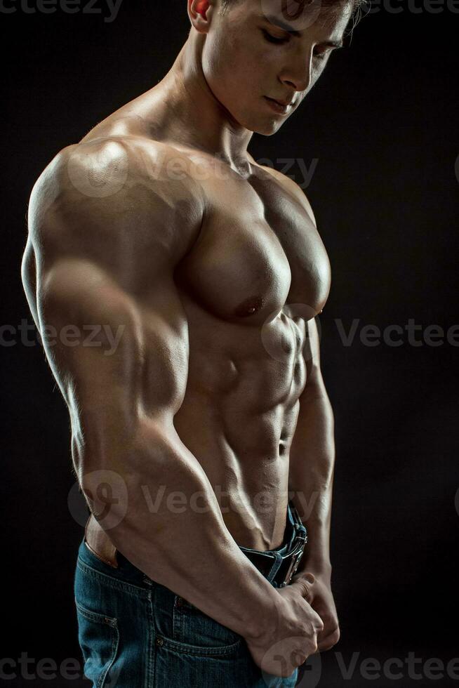 muscular fisiculturista cara fazendo posando sobre Preto fundo foto