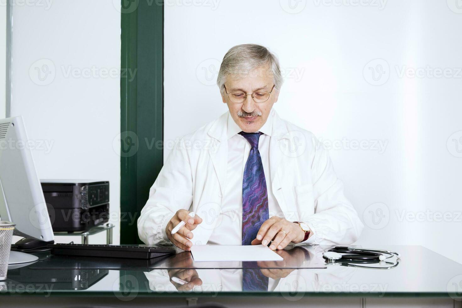 maduro masculino médico sentado às escrivaninha dentro médico quarto foto
