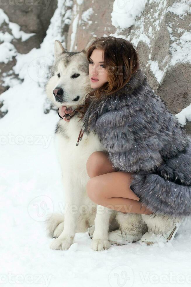 jovem mulher com Lobo cachorro dentro neve foto