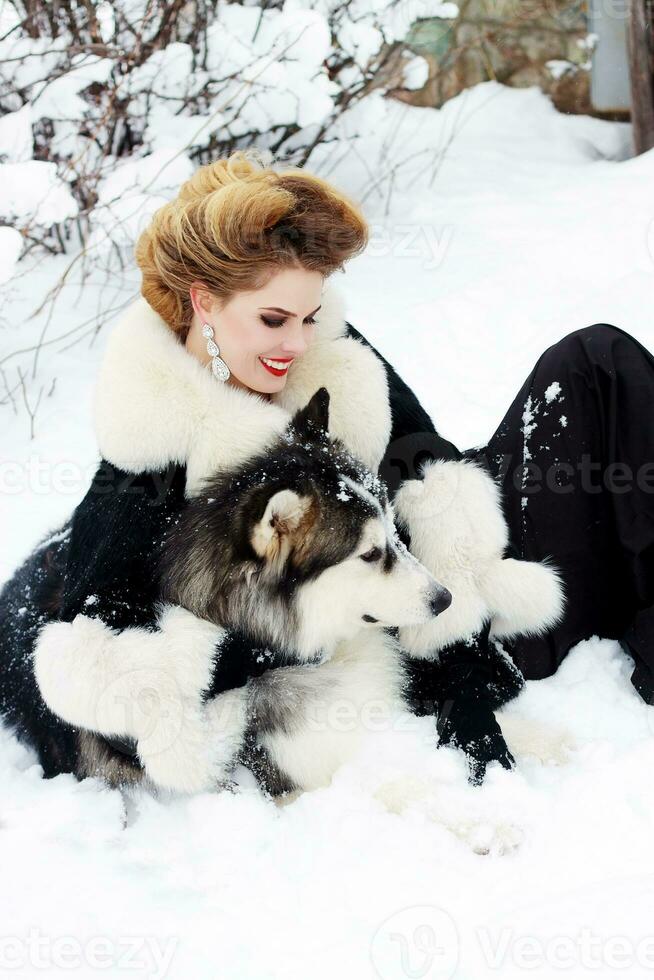 jovem mulher com Lobo cachorro dentro neve foto