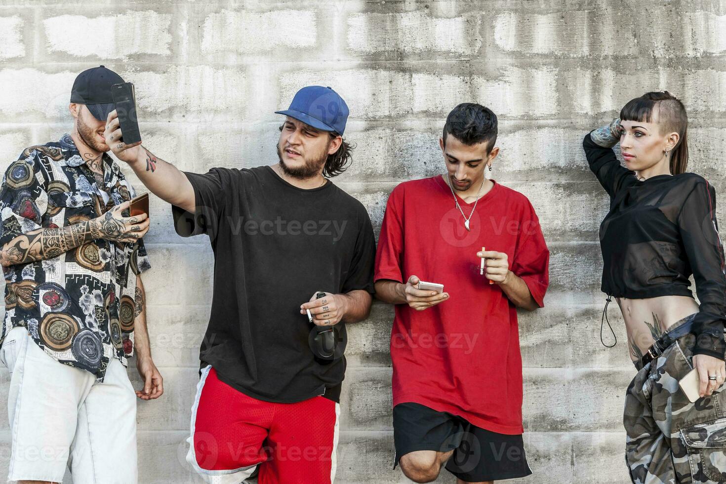 grupo do tatuado amigos usando inteligente telefone foto