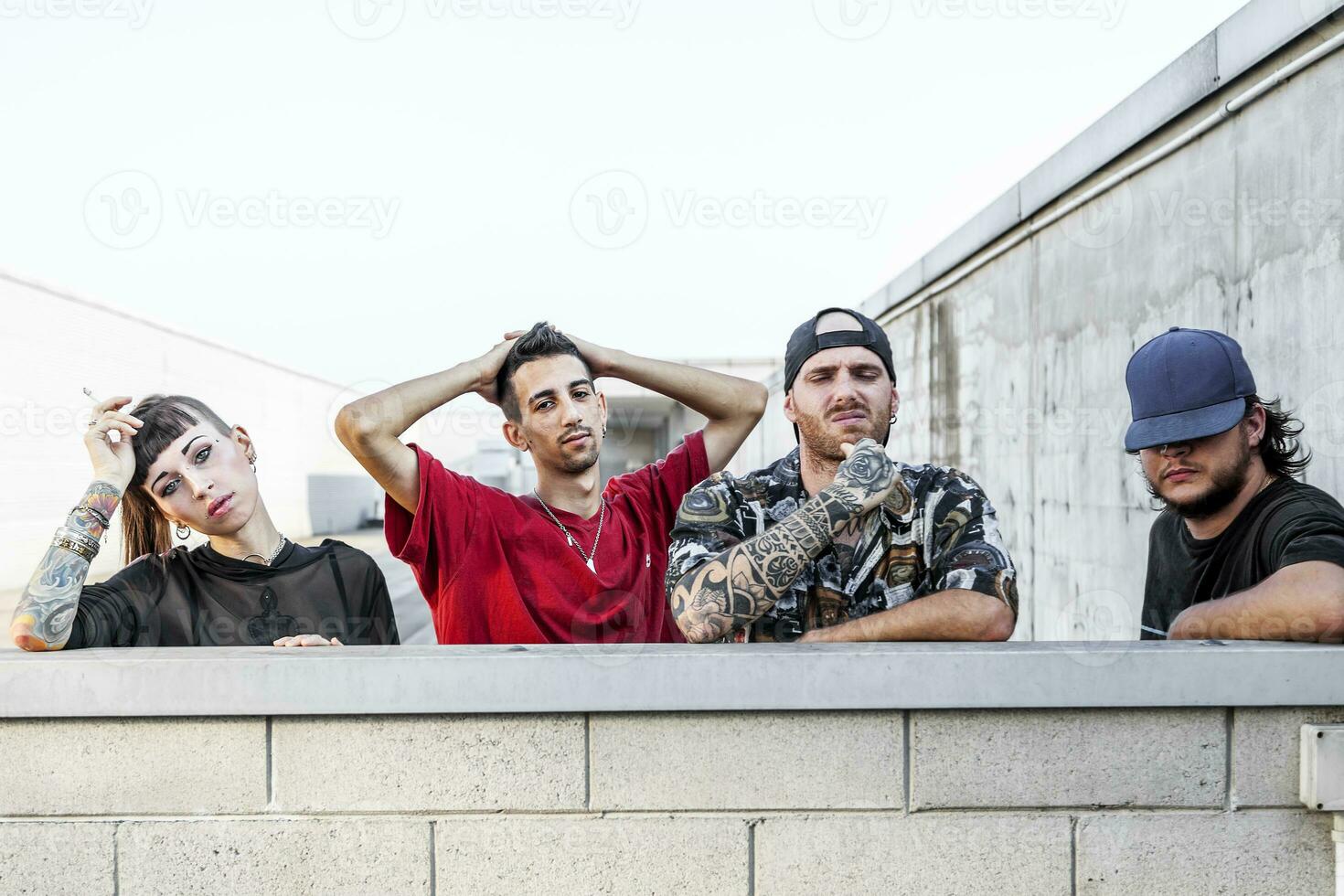 grupo do rappers posando inclinado contra a parede foto