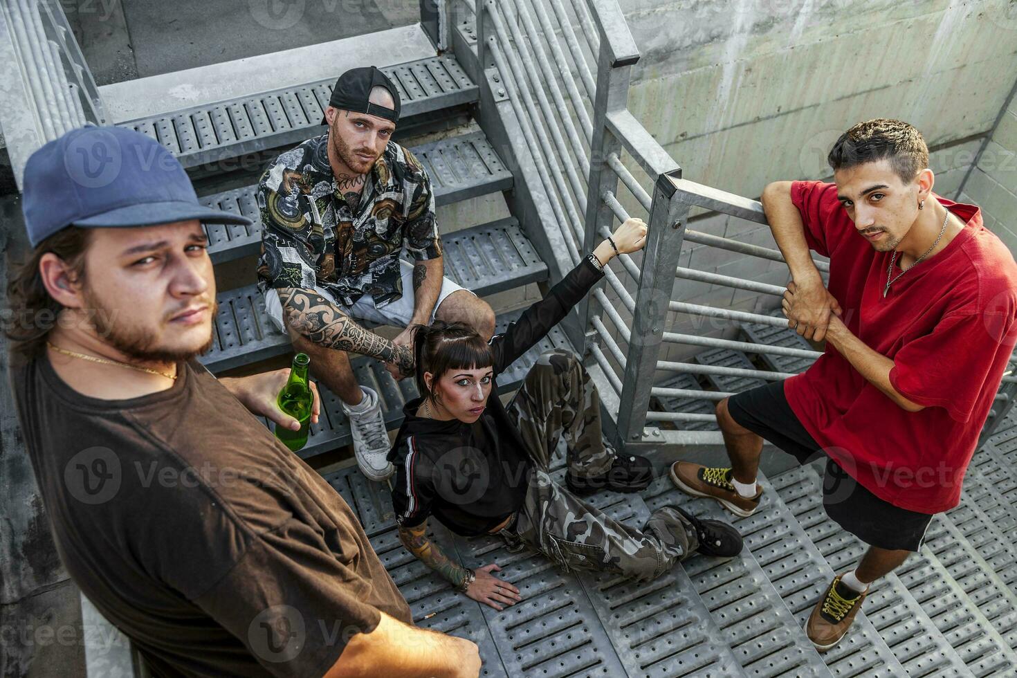 grupo do jovem rappers posando em a metal escadas foto