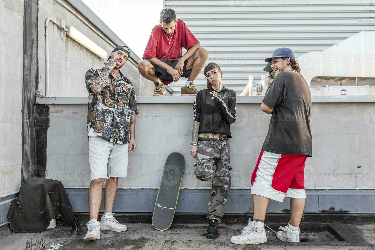 grupo do rappers posando contra a parede em a metal telhados foto