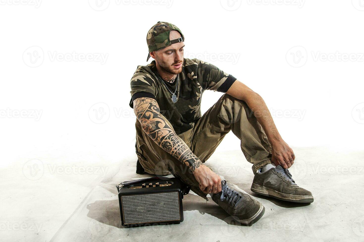 sentado tatuado rap cantor posando dentro estúdio foto