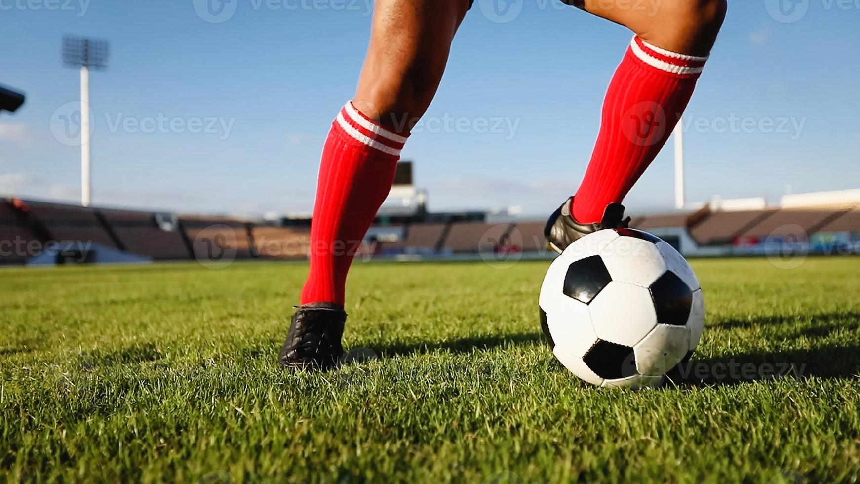 jogador de futebol ou futebol americano em pé com a bola no campo para chutar a bola no estádio de futebol foto