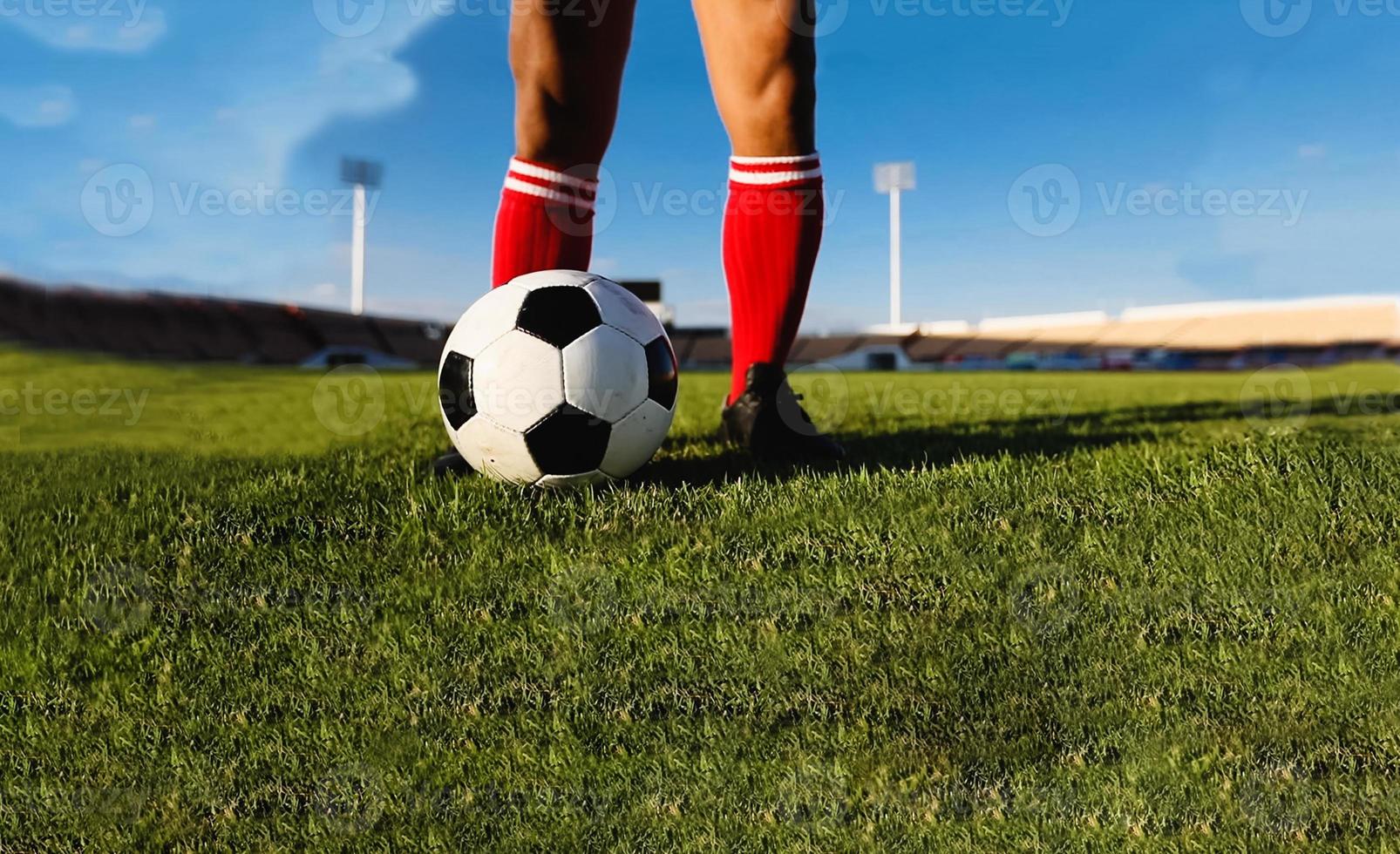 jogador de futebol ou futebol americano em pé com a bola no campo para chutar a bola no estádio de futebol foto