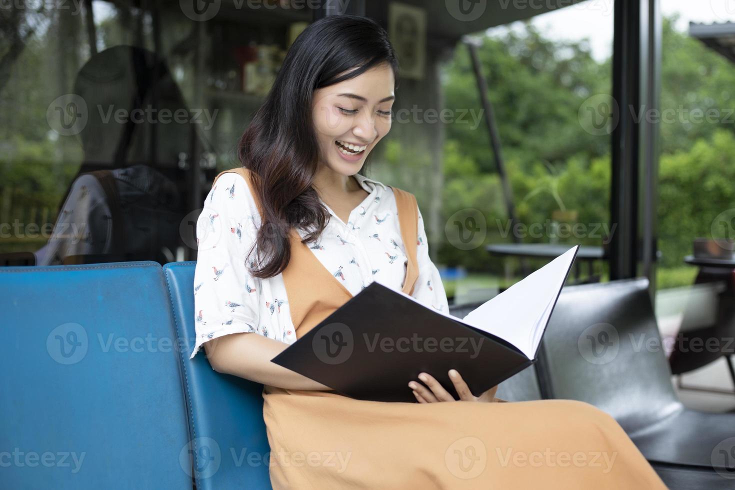 mulheres asiáticas lendo e sorrindo e relaxando felizes em um café depois de trabalhar em um escritório de sucesso. foto